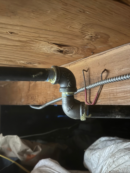 a metal elbow fitting, 1/2 inch in size, connecting two pipes