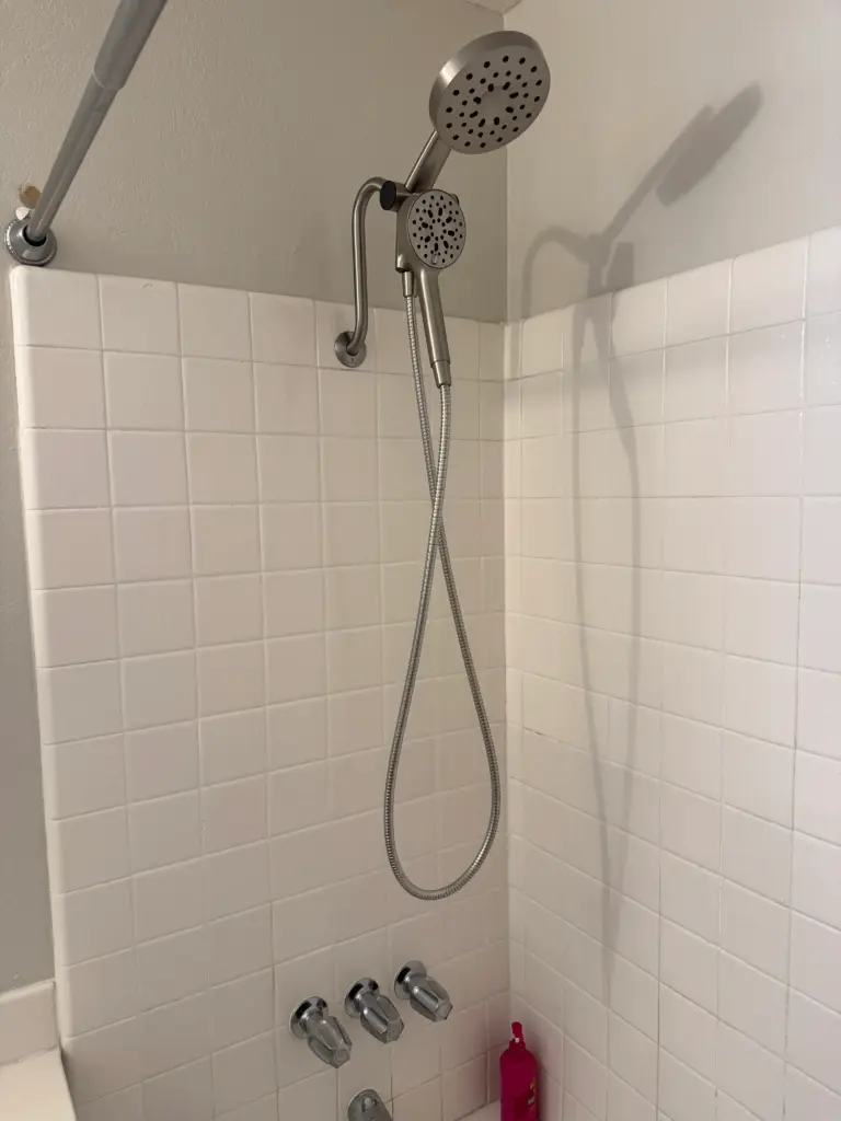Shower fixture being replaced in a tiled bathroom