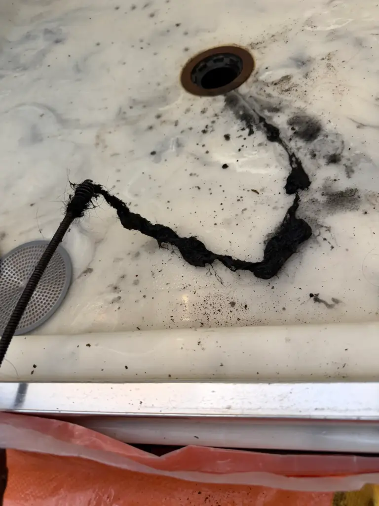 Plumber clearing an outdoor residential drain line