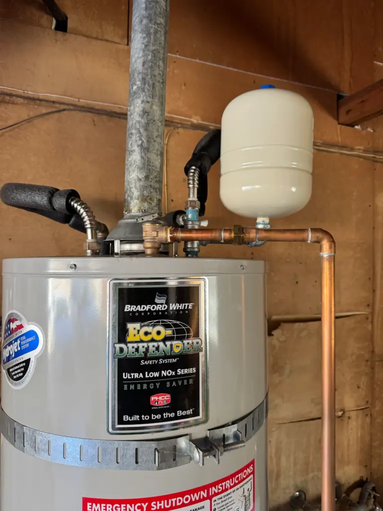 Expansion tank installed above a water heater