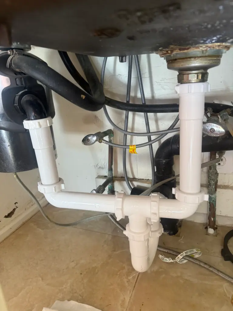 Plumber replacing a sink P-trap and drain piping