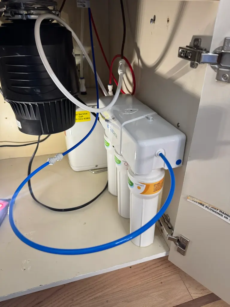 Water filter cartridge replaced beneath a kitchen sink