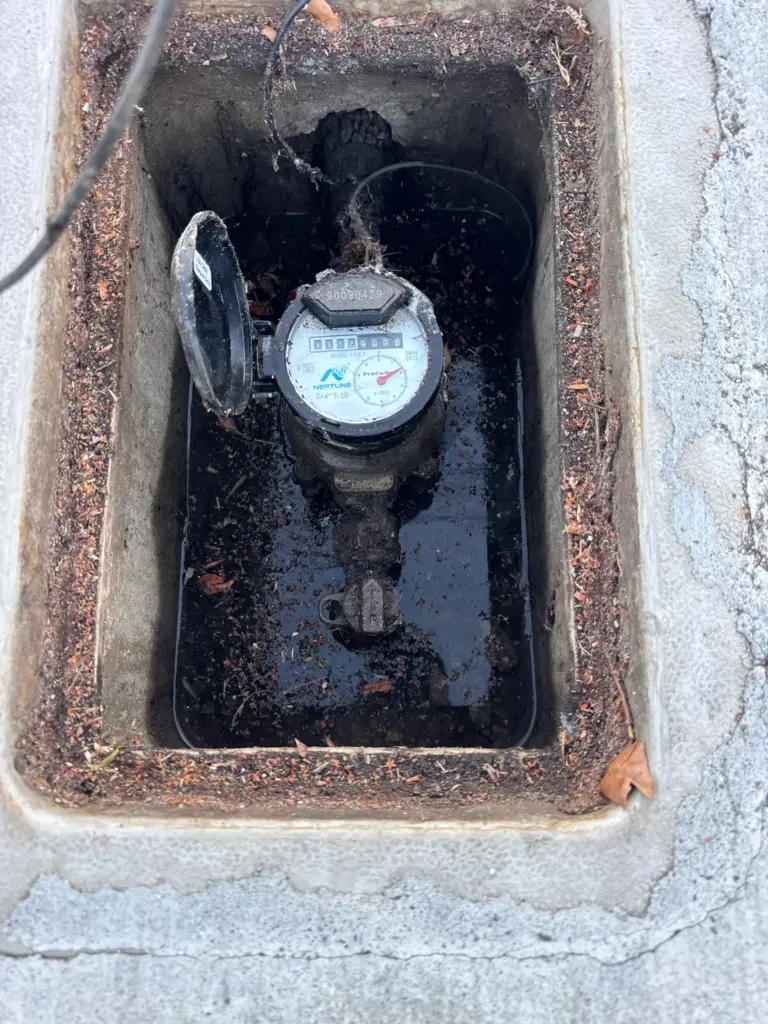 Plumber replacing a shower valve behind a tiled wall