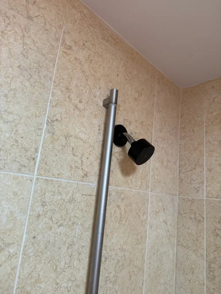 New showerhead installed in a tiled shower