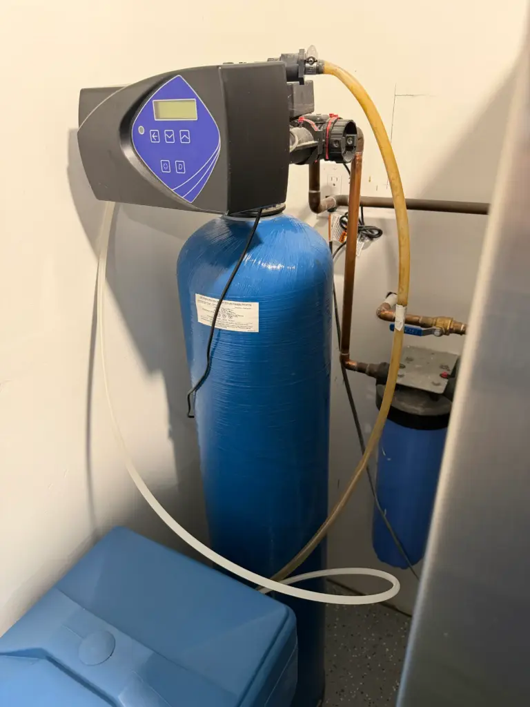 Whole-house water softener installed with plumbing connections