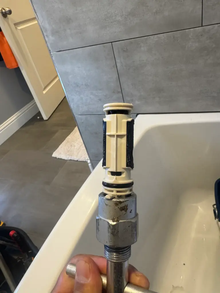 Plumber replacing a shower valve cartridge