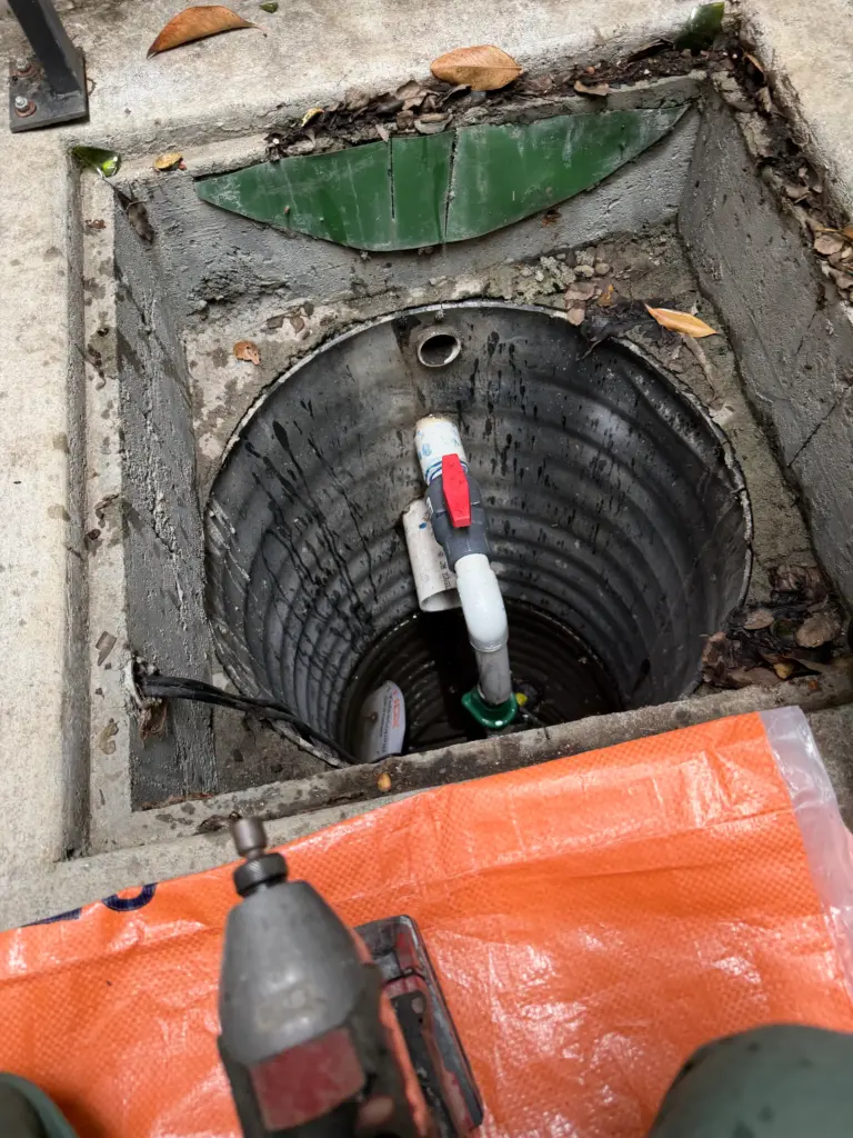 Sump pump basin with pump and discharge piping